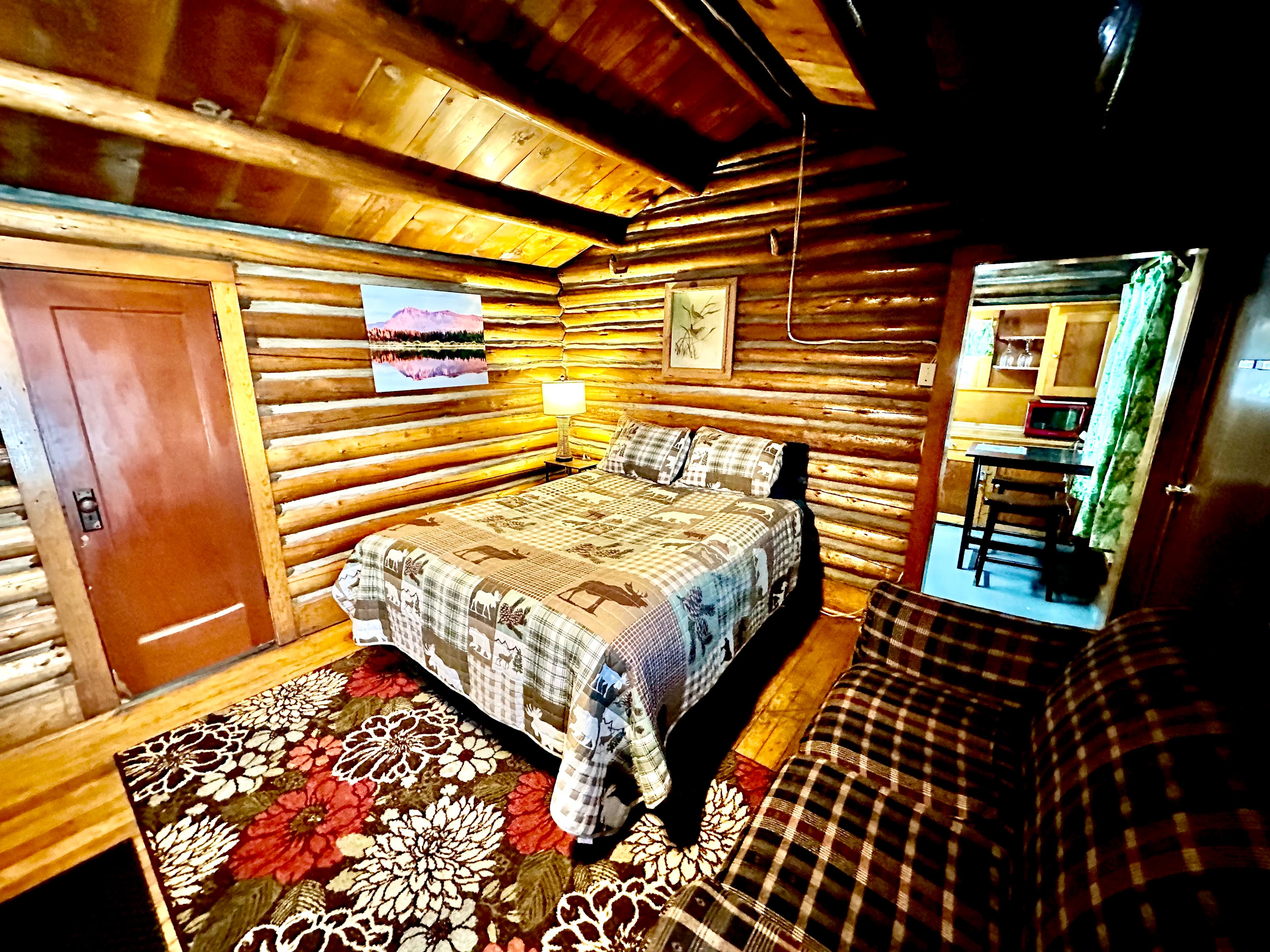 Cozy log cabin interior featuring a bed, seating area, and warm wooden accents.