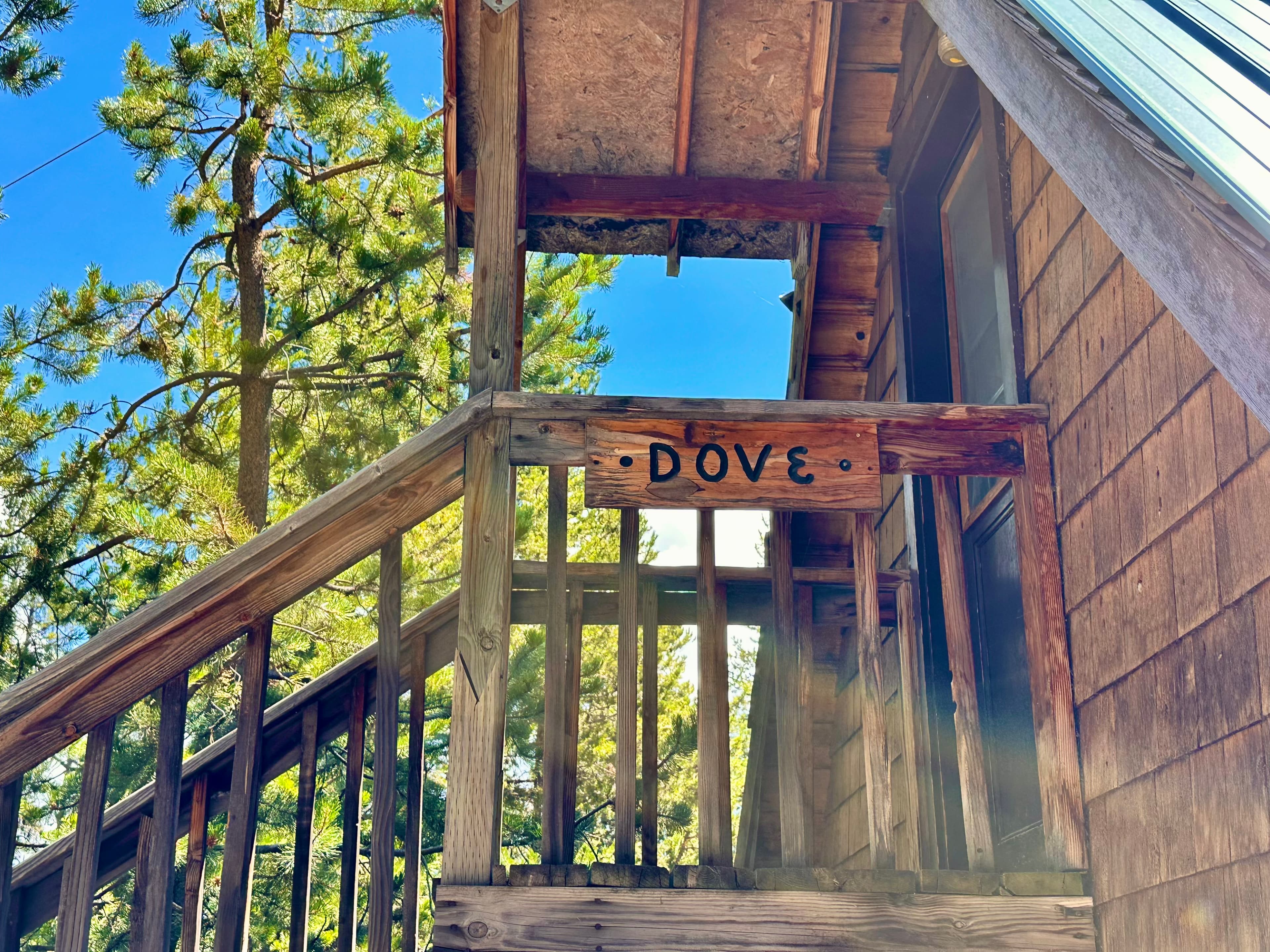 Wooden staircase leading to a cabin with a sign labeled "DOVE."