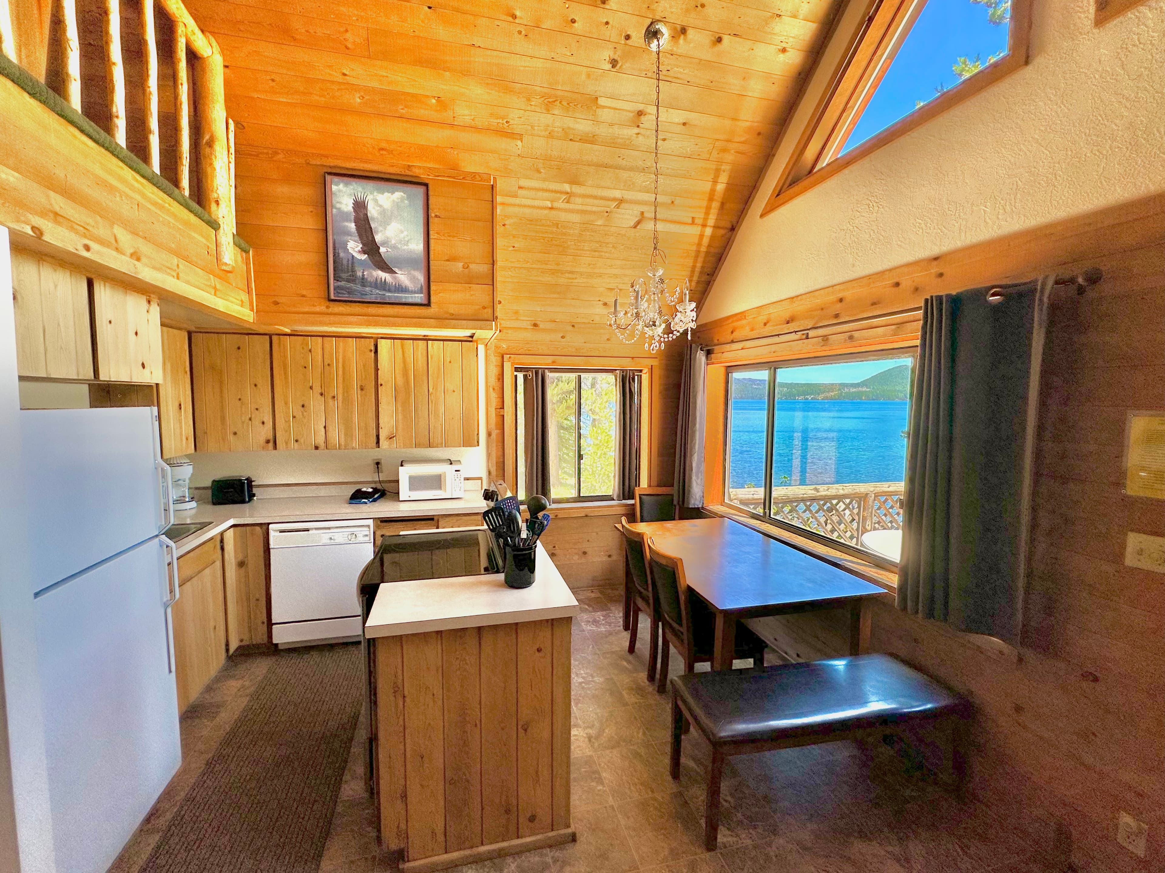 Cozy wooden kitchen with large windows offering a view of the lake.
